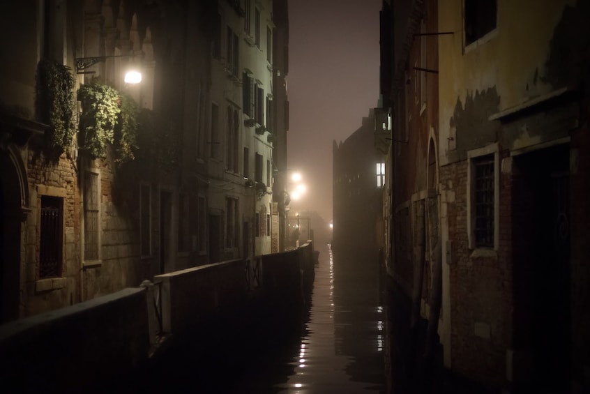 Narrow Venetian canal at night