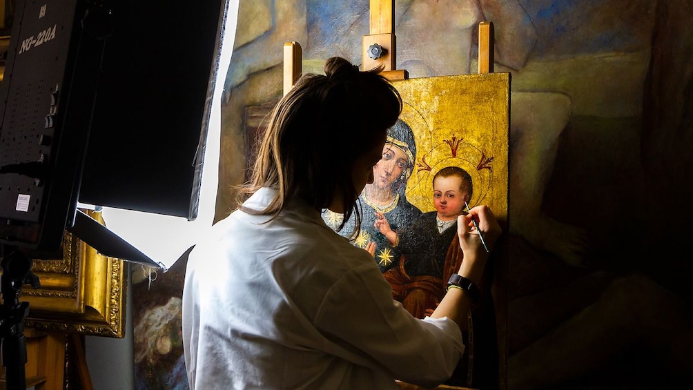 Painter retouches a painting of Mary and Jesus