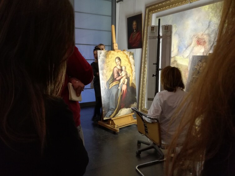 Painting of madonna and child lit up at restoration lab
