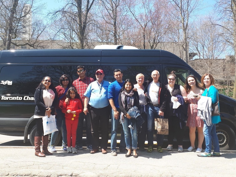 Tour group poses in front of van in Toronto, Canada