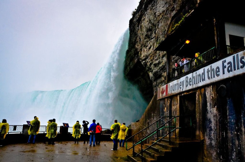 Tourists stand on balcony next to Niagara Falls