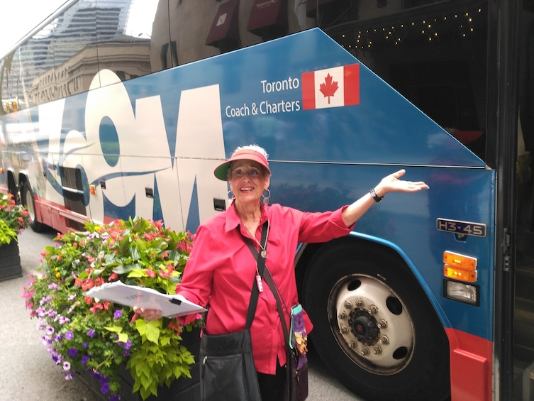 Tour guide poses outside tour bus