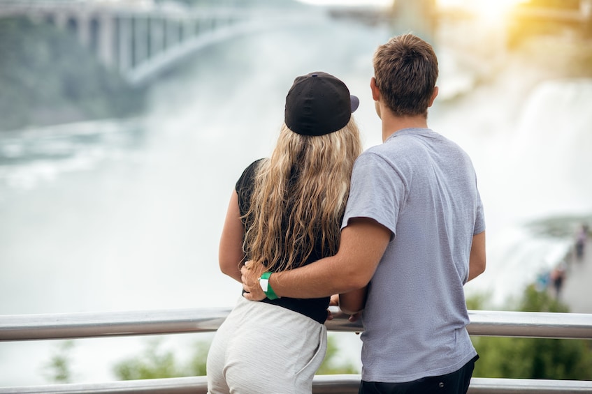 Couple look at Niagara Falls from balcony