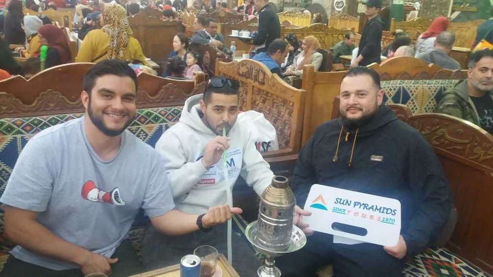 Three man sit with a hookah in Cairo, Egypt