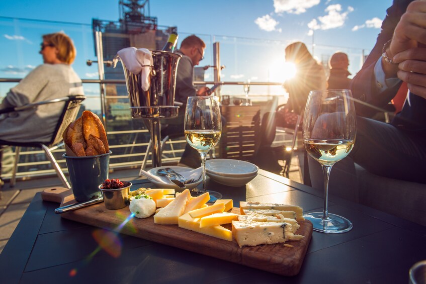 People enjoy wine and cheese on a plaza on the Mediterranean coast