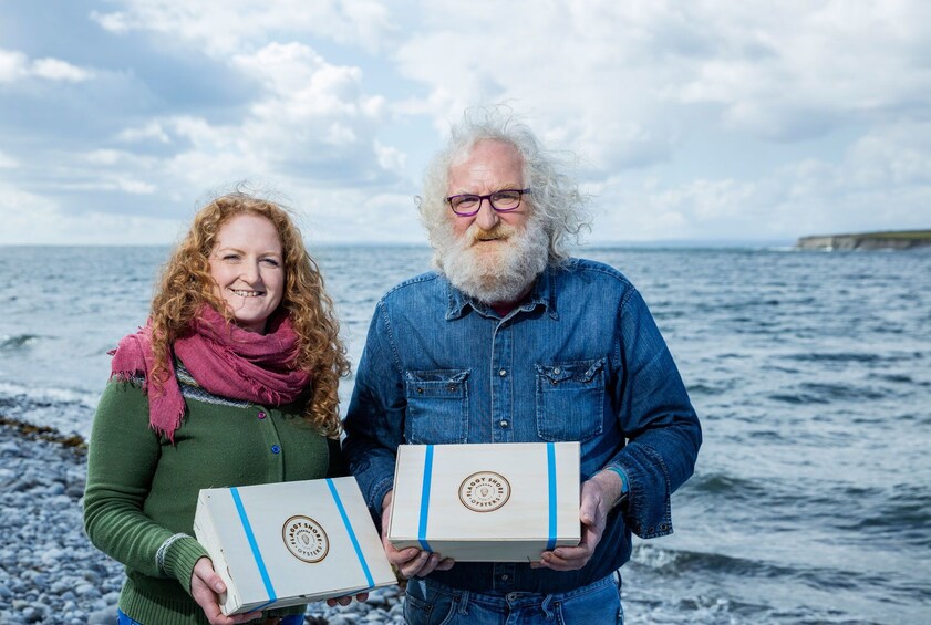 Show item 4 of 7. Two people holding boxes of oysters on Flaggy Shore