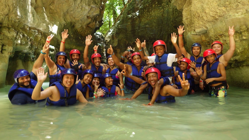 Tour group pose in water in the Dominican Republic