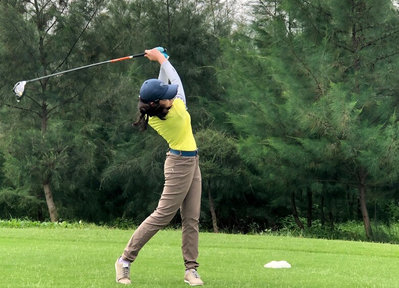 Golfer finishes club swing on Vietnamese golf course