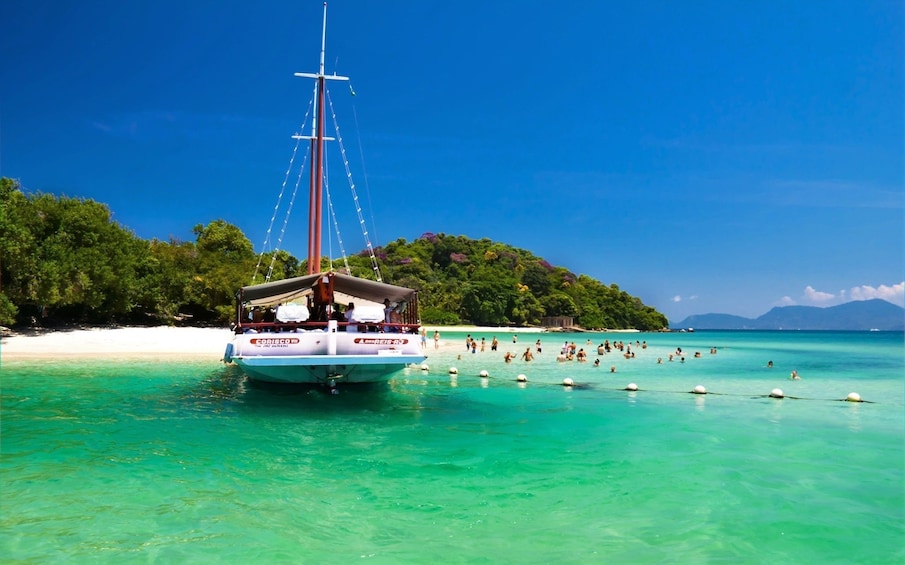 Large boat approaches beach in Angra Dos Reis, Brazil