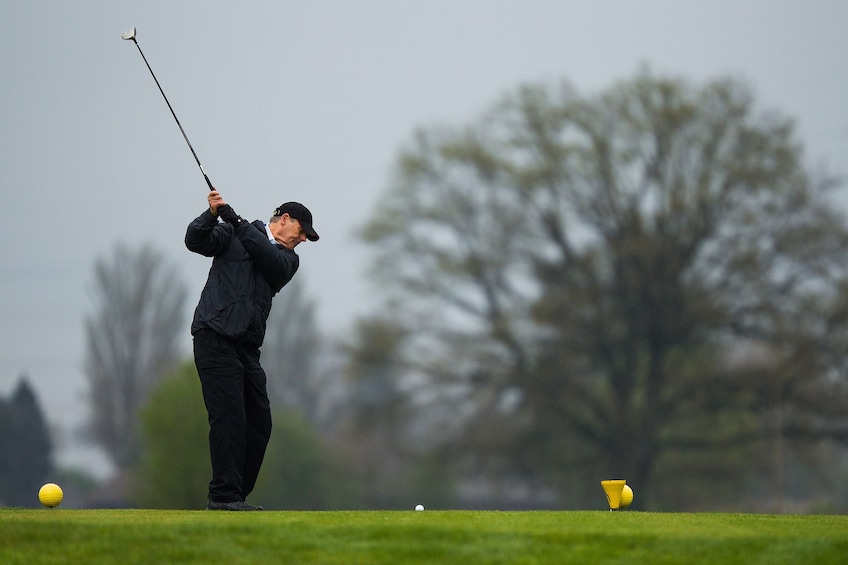 Golfer mid-swing on a gray day