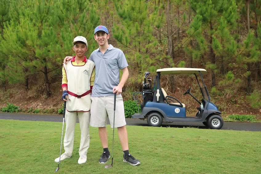 Two golfers pose at Sacom Tuyen Lam Golf Resort