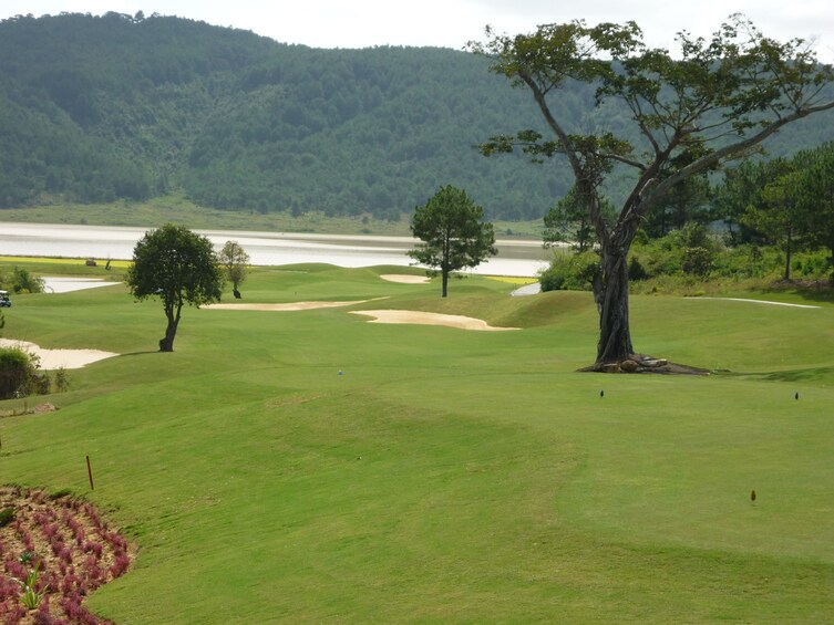 Golf course with small lake and mountains in the background