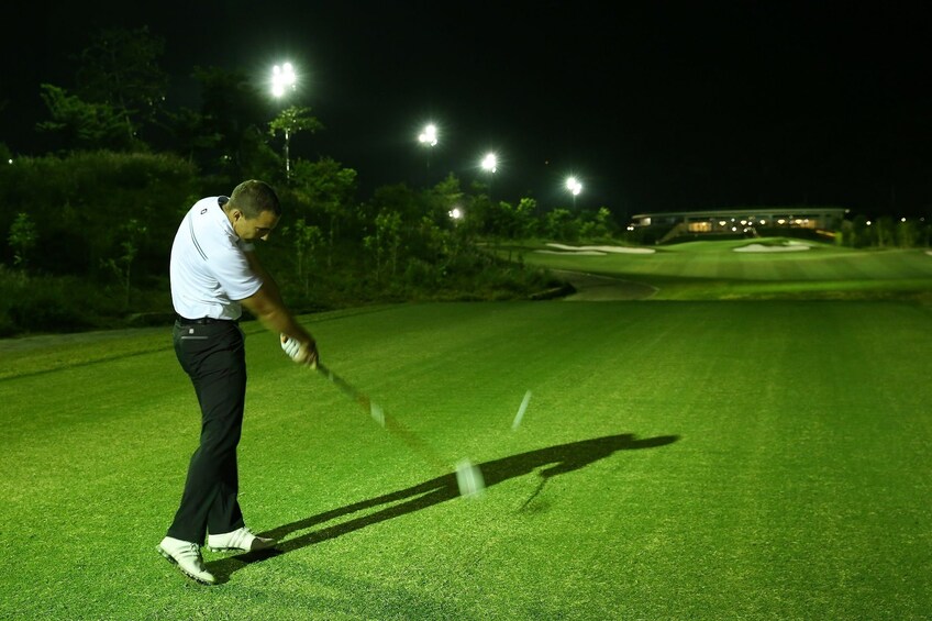 Man golfing at night at a golf club in Vietnam