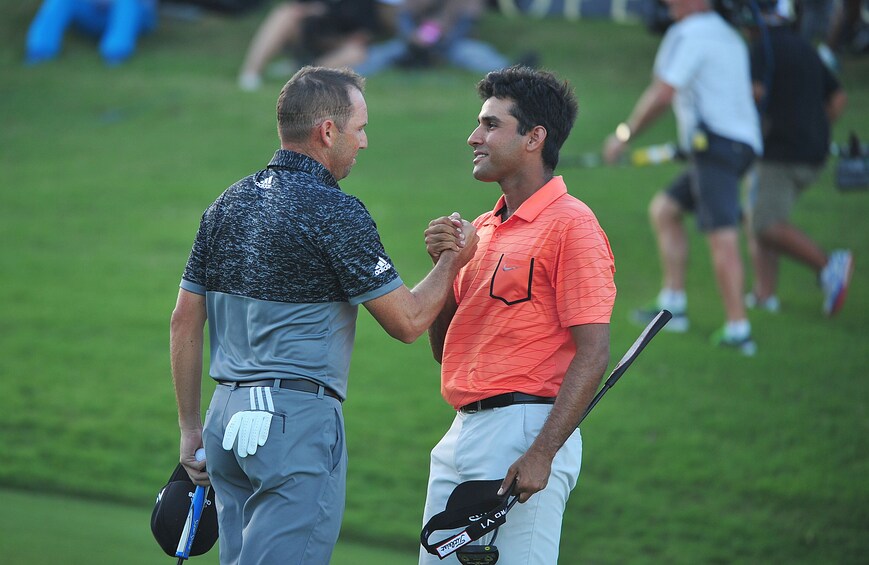 Two golfers shake hands on the course