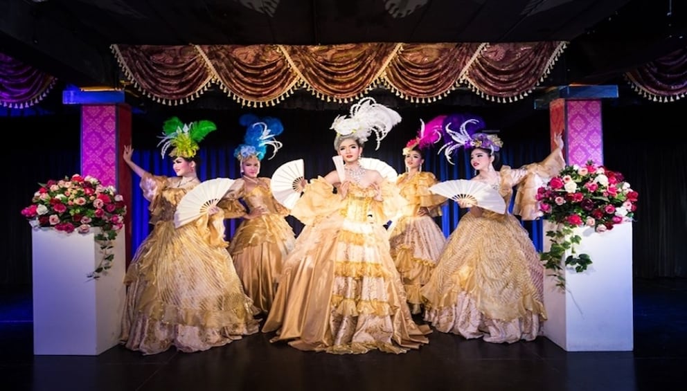 Performers wear ball gowns and feather hats