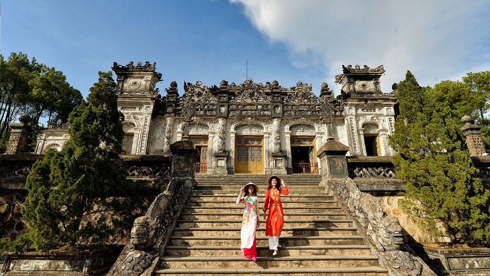 Two woman stand on the steps outside the Royal Tomb of Khai Dinh King