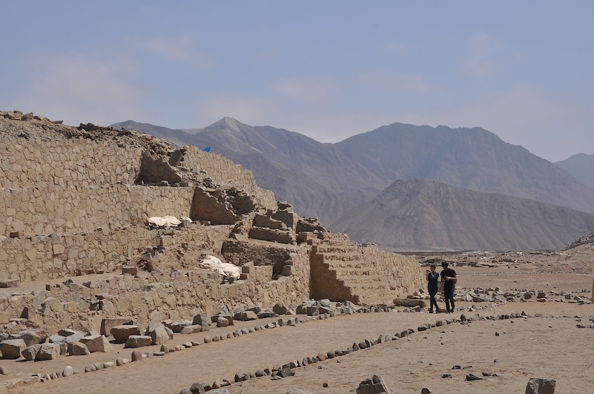 People walk along path through Caral settlement