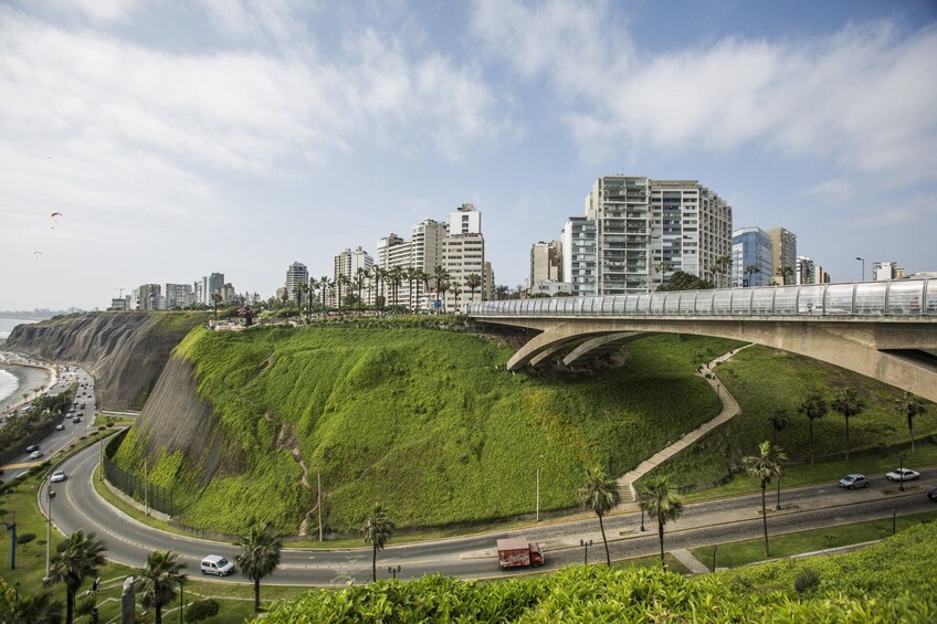 Office buildings, grassy hill and highway in Lima, Peru