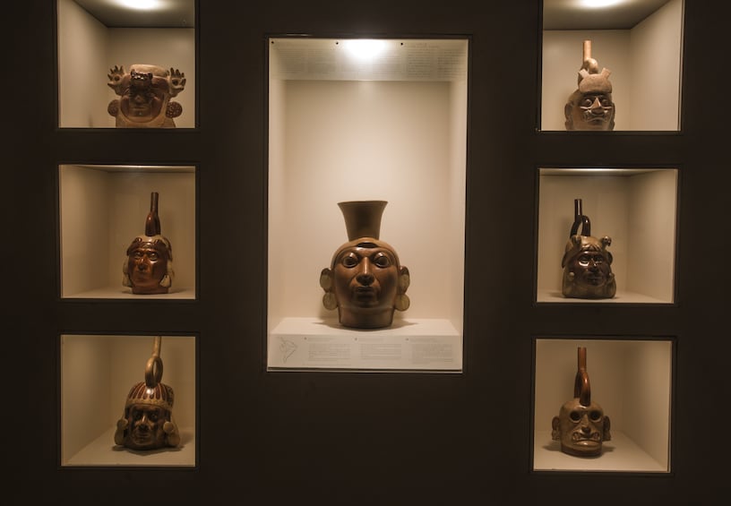Display of vases with faces at the Larco Museum