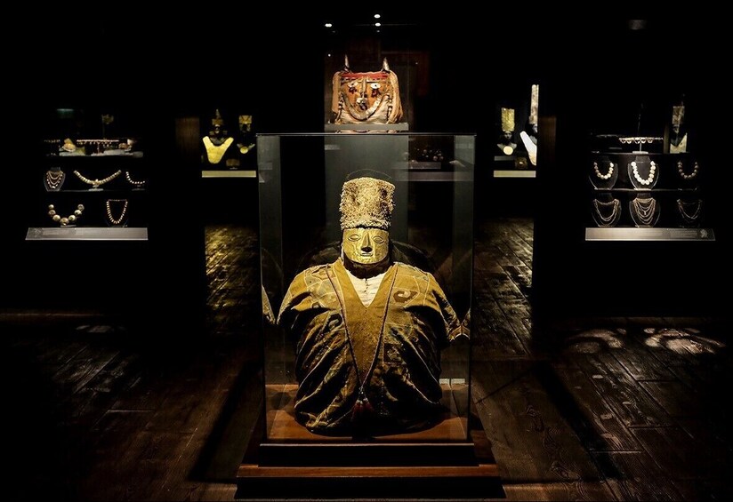 Statues and jewelry in cases at the Larco Museum