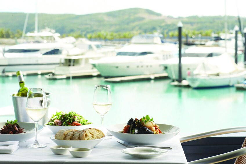 Table with salad and bread looking out over pier of Hamilton Island
