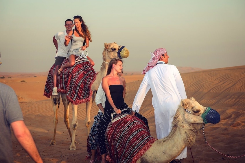 Tourists ride camels in Dubai