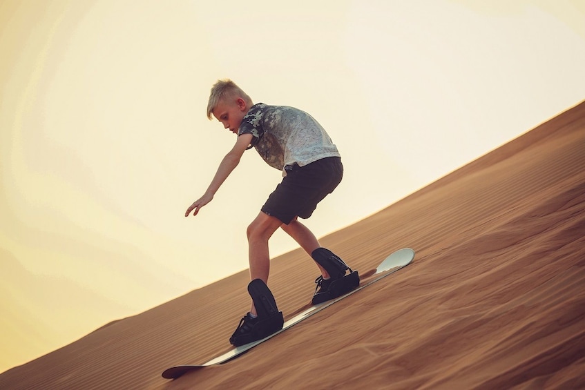 Boy sand surfing in Dubai