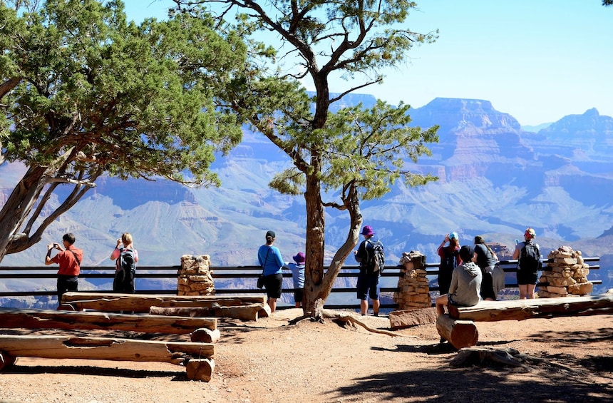 Tourists taking photos of Grand Canyon National Park on a sunny day