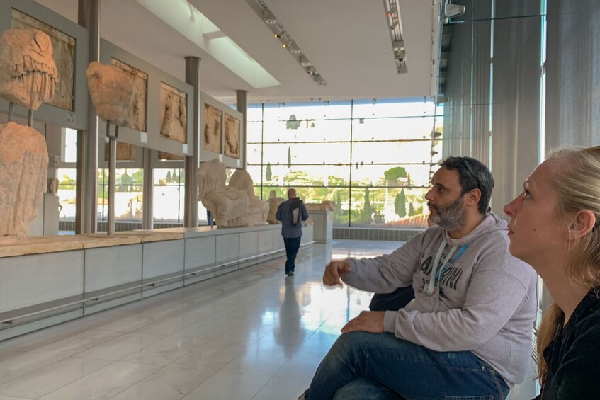 Two people look on at an exhibit at the Acropolis Museum
