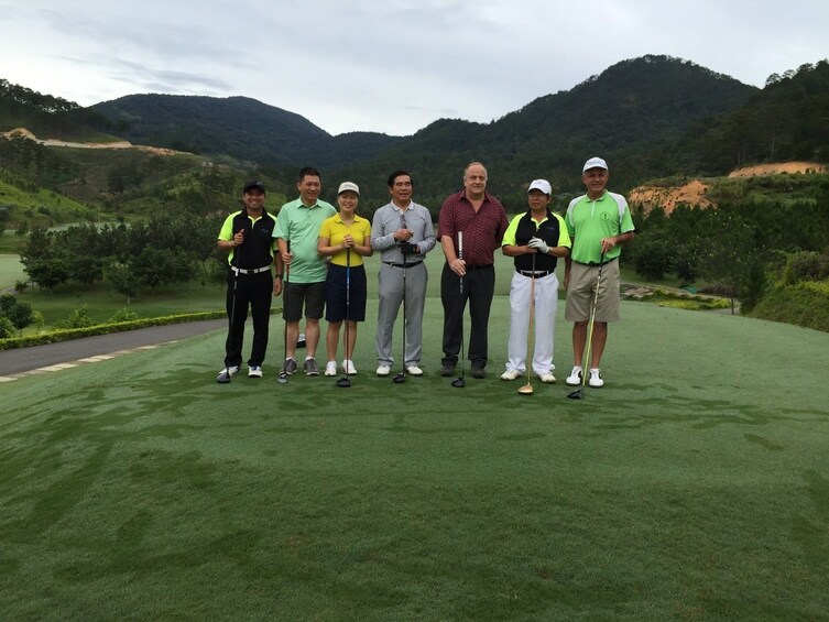 Group of golfers pose on golf course in Vietnam