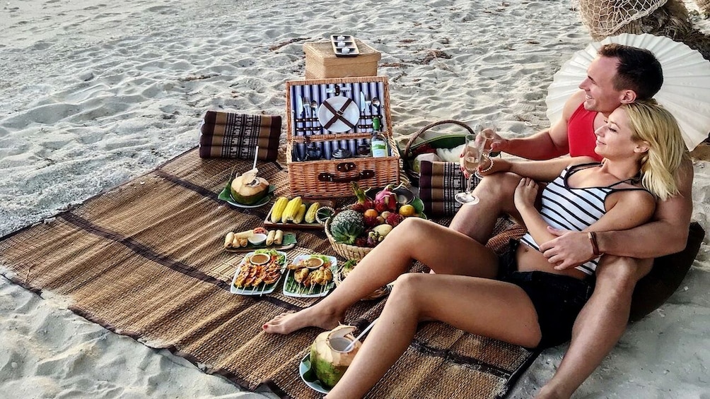 Couple enjoy champagne during picnic in Thailand