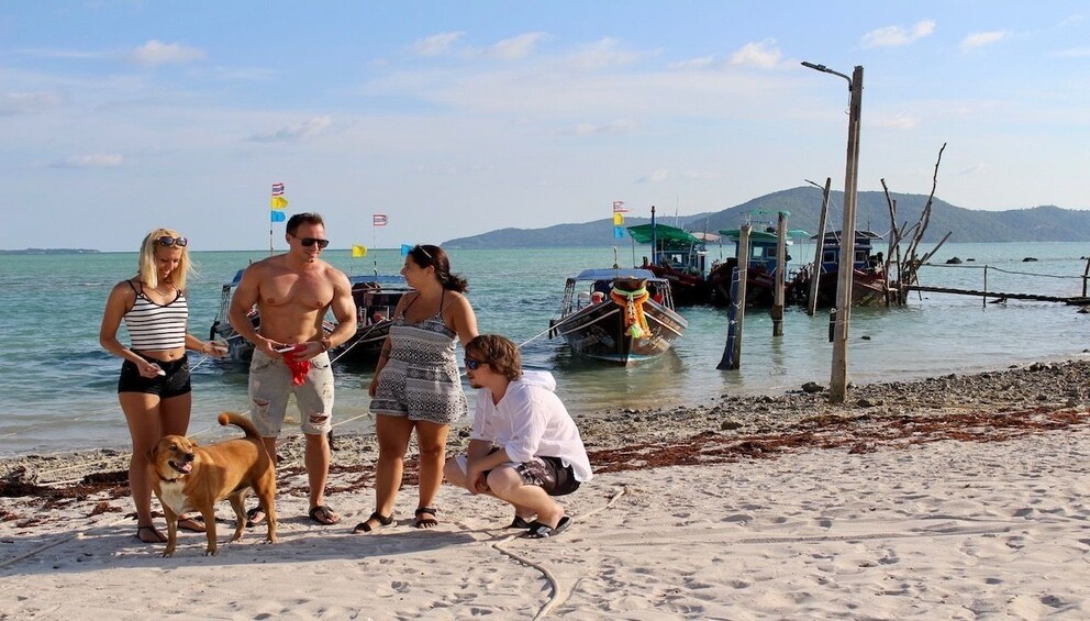 Small group and dog on beach in Thailand