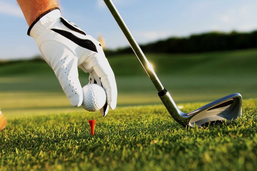 Golfer places golf ball on the tee