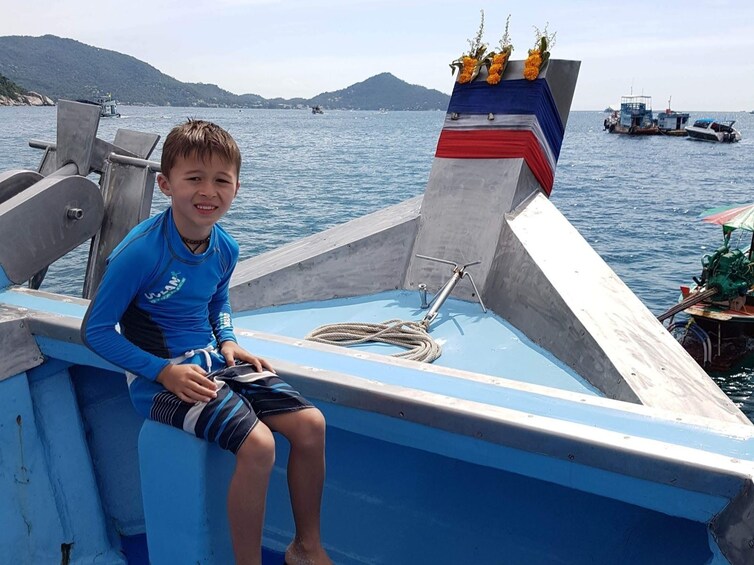 Child sitting on a boat in Thailand