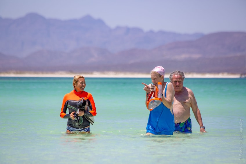 Three people prepare to snorkel near Coronado Island in Mexico