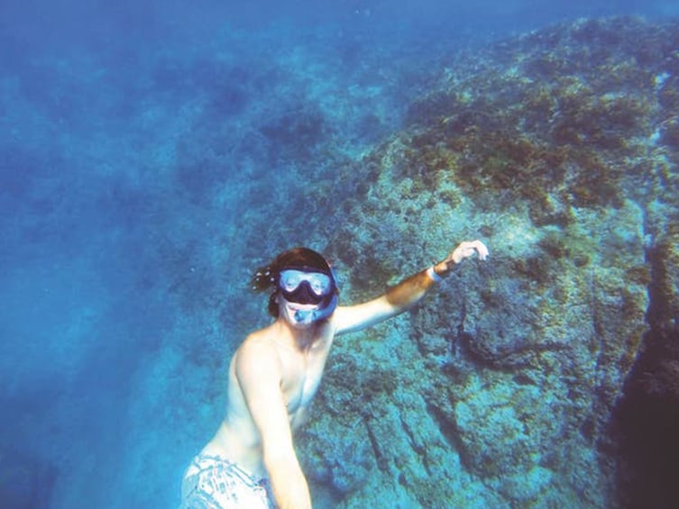 Woman snorkels near coral reefs in Mexico