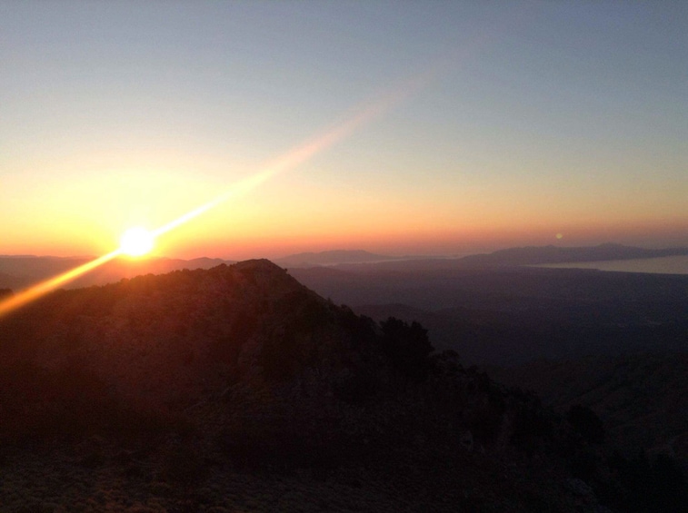 Sun sets over the mountains and waters of Vatolakkos, Greece