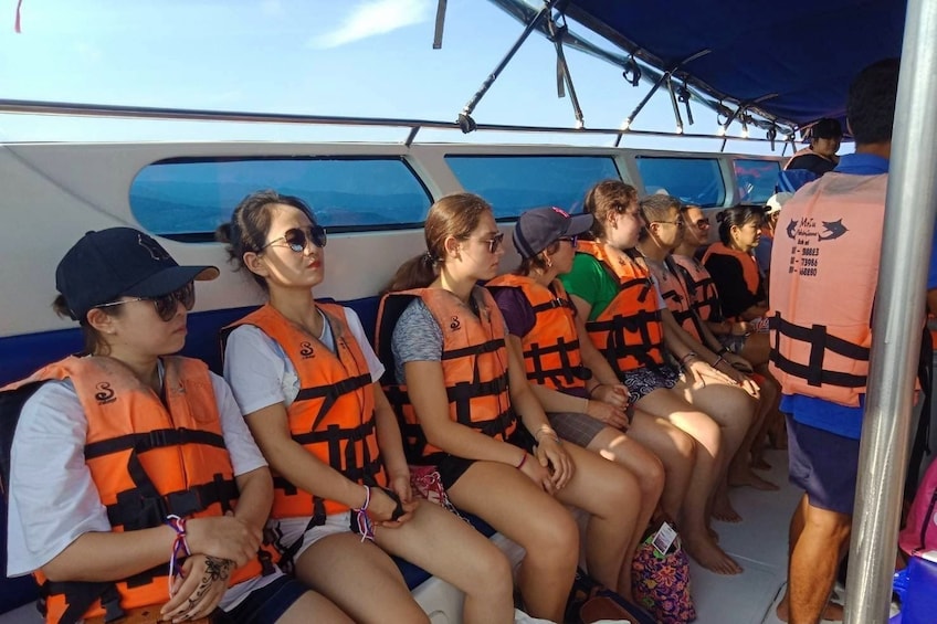 Tourists sit on boat with life vests on 