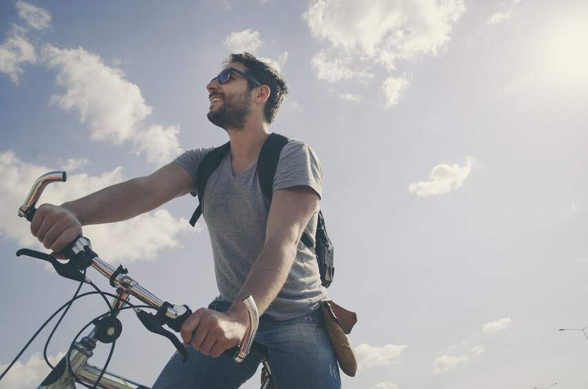 View from below of man biking in Fasano, Italy