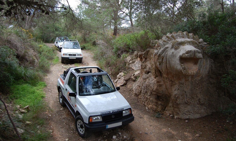 Jeep parked by dragon statue in the woods of Mallorca