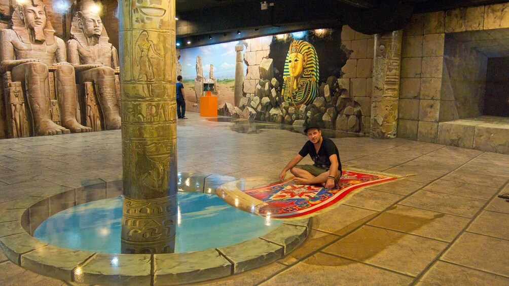 Man poses on magic carpet at Art in Paradise Chiang Mai