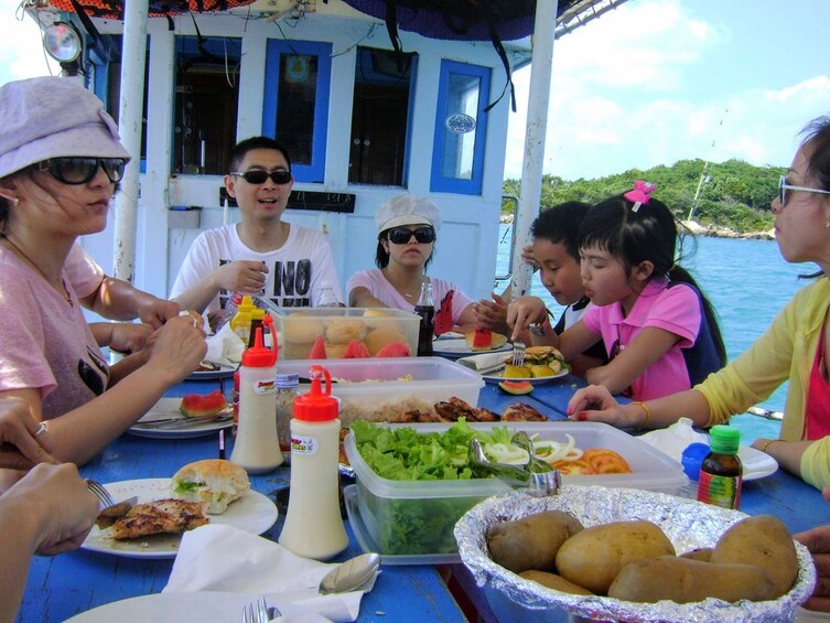 Tourists enjoy lunch on fishing boat in the Gulf of Thailand