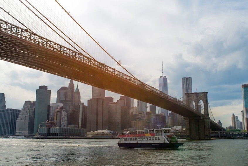 Boat cruise passing under the Brooklyn Bridge in New York City, New York
