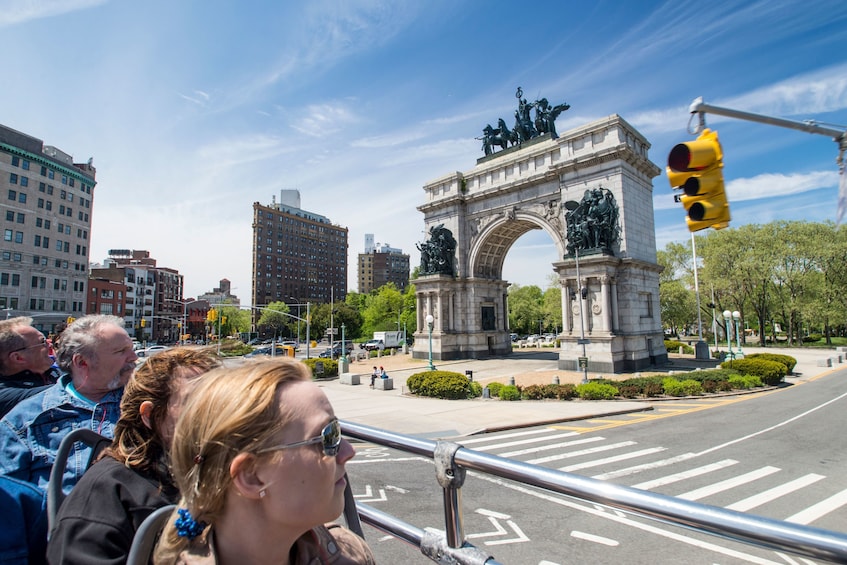 City Sightseeing hop-on hop-off bus passes by the Grand Army Plaza Park in Brooklyn, New York