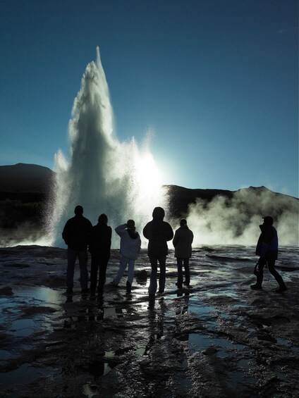 Tour group viewing erupting geysers at Iceland's Golden Circle