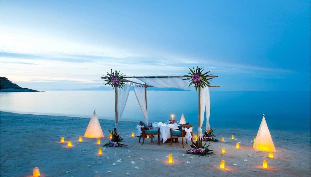 Romantic dining table on the beach in Thailand at dusk
