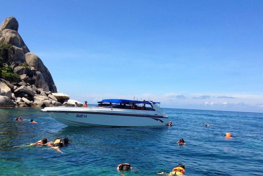 Tourists swim around speedboat near Thai island