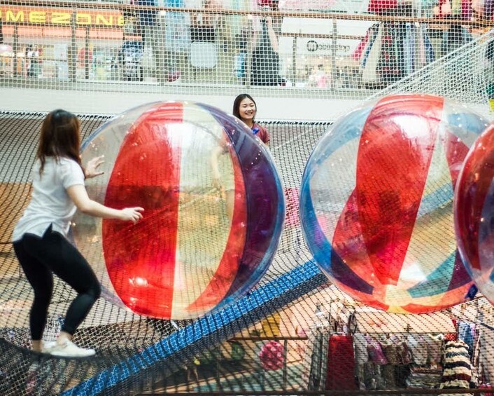 People at Air Zone push large inflated balls