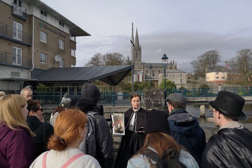 Meeting point on Riverside, next to the Riverside Hotel with footbridge and church in background.