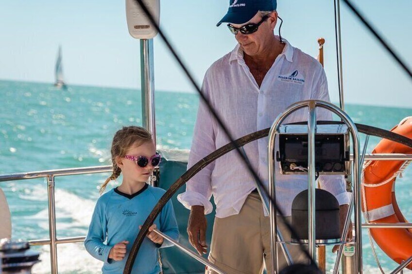 Skipper showing little girl how to steer